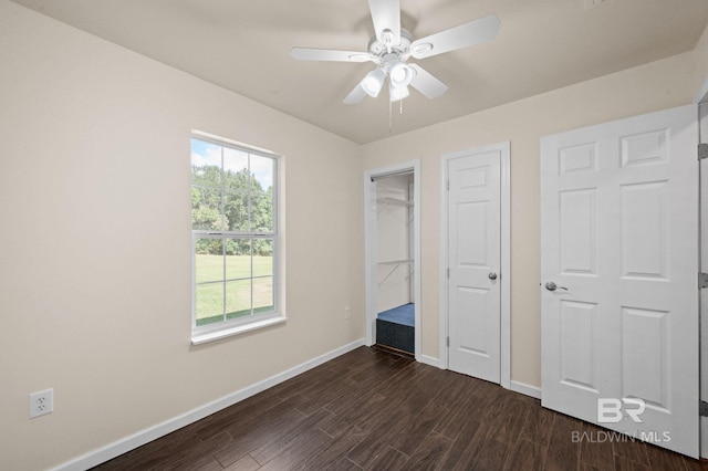 unfurnished bedroom with ceiling fan and dark hardwood / wood-style floors