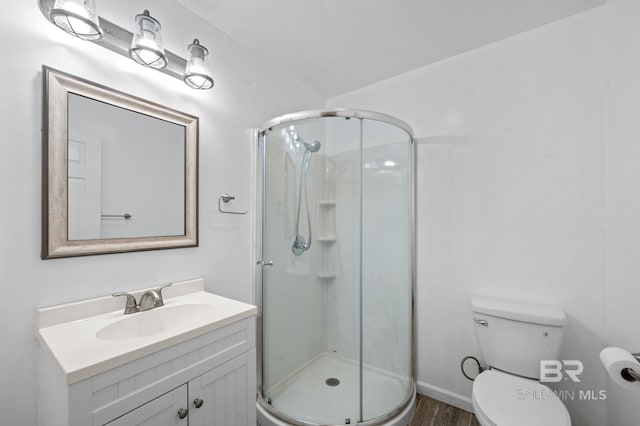 bathroom with a shower with door, vanity, hardwood / wood-style floors, and toilet