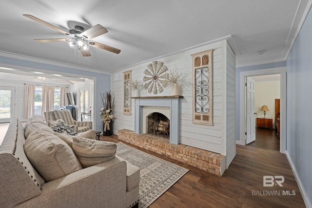 living room with a fireplace, dark hardwood / wood-style flooring, ceiling fan, and ornamental molding