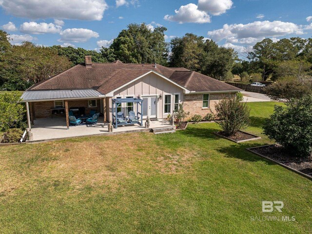 rear view of property featuring a patio area and a yard