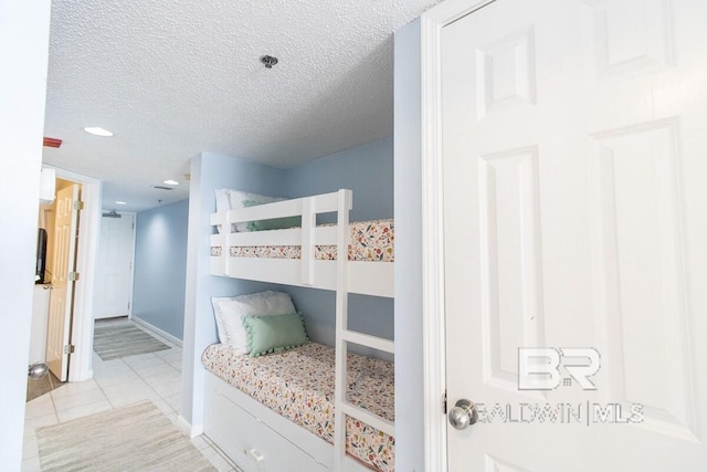 bedroom with light tile floors and a textured ceiling