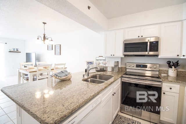 kitchen featuring light stone countertops, stainless steel appliances, white cabinetry, sink, and an inviting chandelier