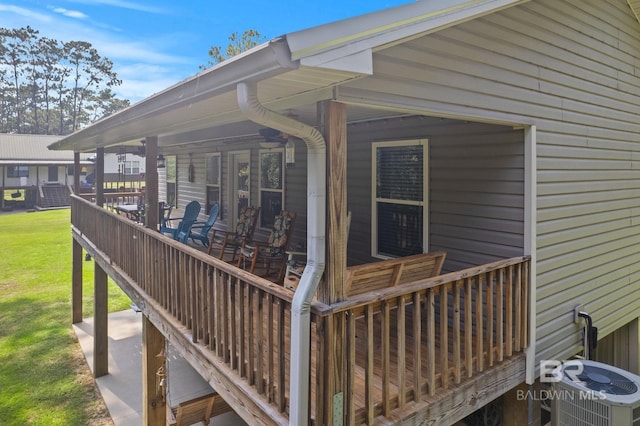 wooden terrace featuring a lawn and cooling unit