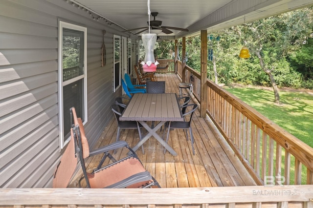 wooden terrace featuring ceiling fan and a yard