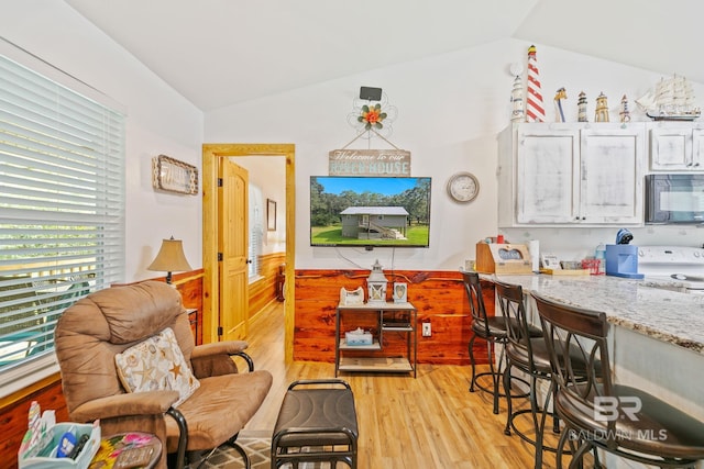 dining area featuring vaulted ceiling and light wood-type flooring