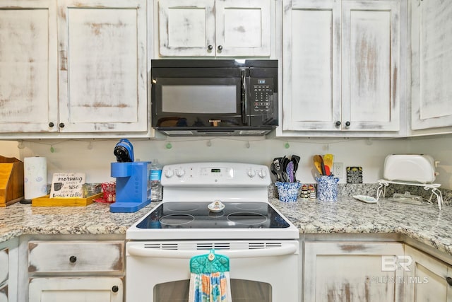 kitchen with white electric range oven, black microwave, and light stone counters