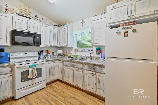 kitchen with white appliances, a sink, vaulted ceiling, and light wood-style floors
