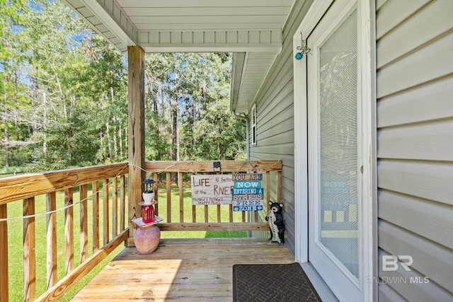 wooden terrace with view of wooded area