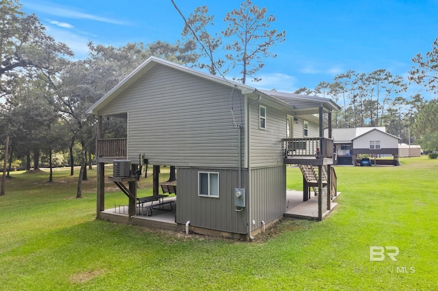 view of property exterior featuring a yard, a deck, a patio area, and stairs