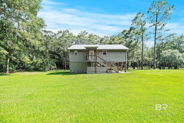back of house featuring a yard and metal roof