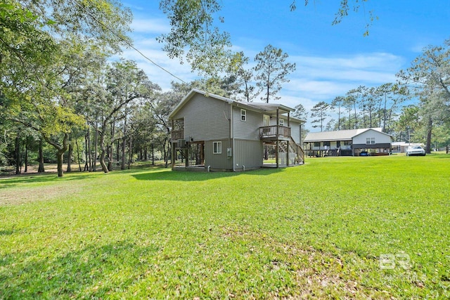 back of property with stairway, a yard, and a deck