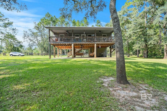 rear view of house with ceiling fan, stairway, and a deck