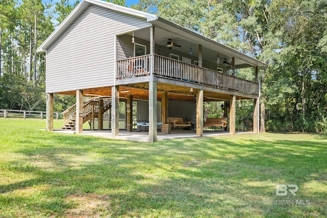 rear view of property featuring ceiling fan, a patio area, a yard, and a deck