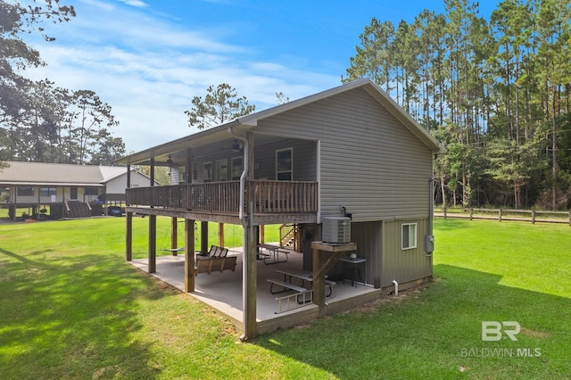 back of property featuring a patio, cooling unit, a lawn, and a wooden deck