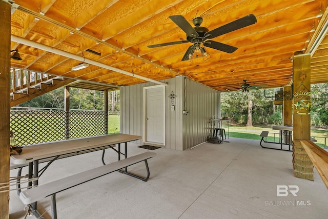 view of patio with ceiling fan and stairs