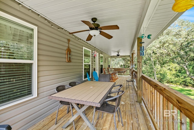 wooden terrace featuring outdoor dining space and ceiling fan