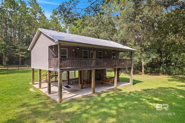 rear view of property featuring ceiling fan, a patio, a deck, and a yard