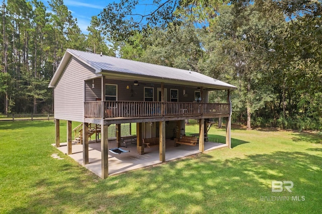 back of house with a patio area, a wooden deck, a lawn, stairs, and metal roof