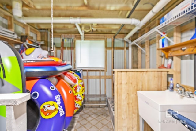 basement featuring sink and tile patterned flooring