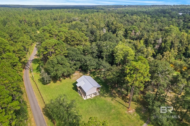 aerial view of property and surrounding area featuring a heavily wooded area