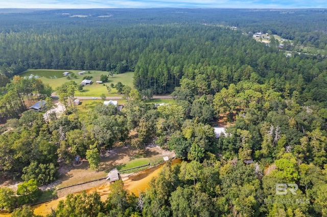 aerial view of property and surrounding area with a heavily wooded area
