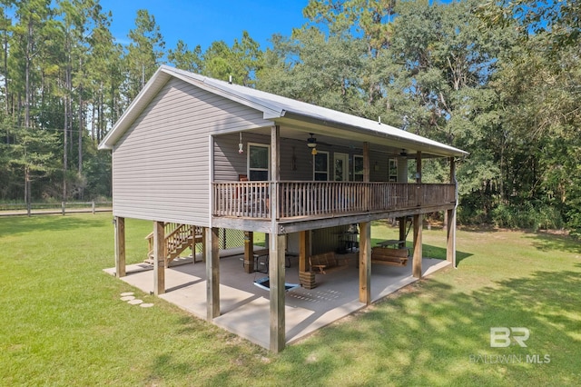 view of front of property with ceiling fan, a patio, a deck, and a front lawn