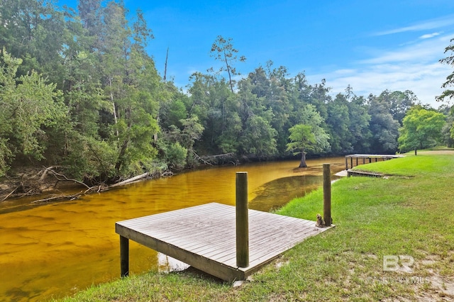 view of dock with a water view and a yard