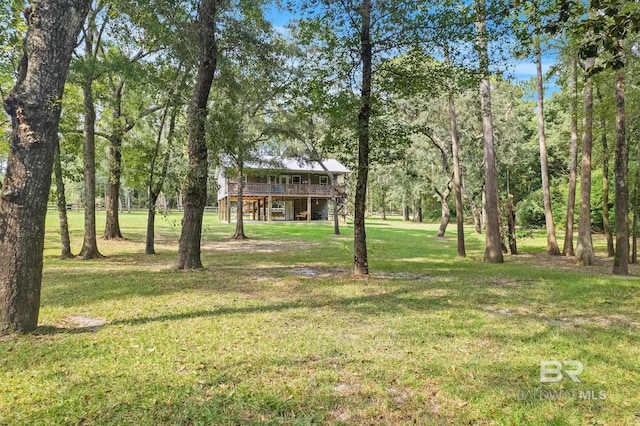 view of green lawn with a deck