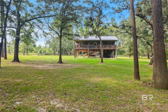 view of grassy yard featuring a deck and stairway