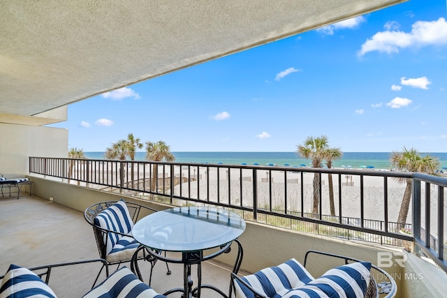 balcony with a water view and a beach view