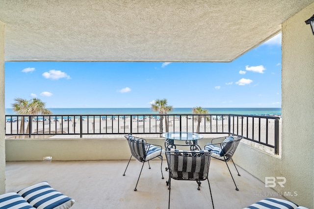 balcony featuring a water view and a view of the beach