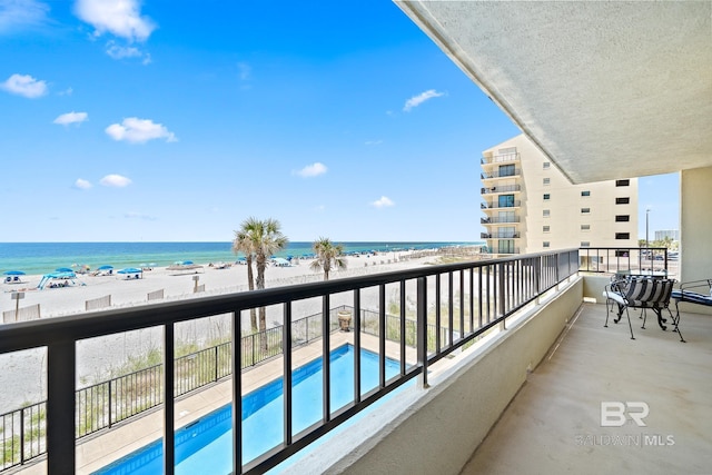 balcony featuring a water view and a view of the beach