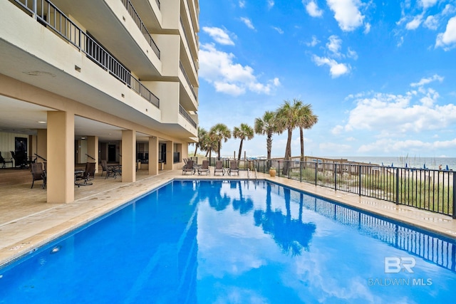 view of pool with a water view and a patio area