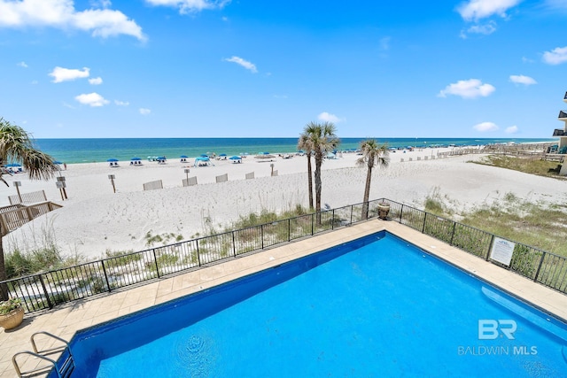 view of pool with a water view and a beach view