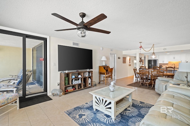 tiled living room featuring ceiling fan and a textured ceiling