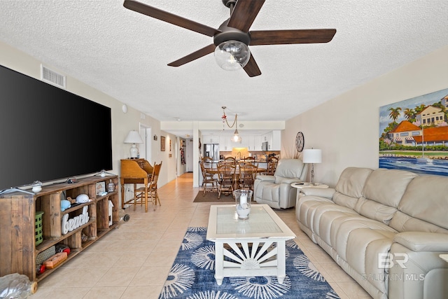 tiled living room featuring ceiling fan and a textured ceiling