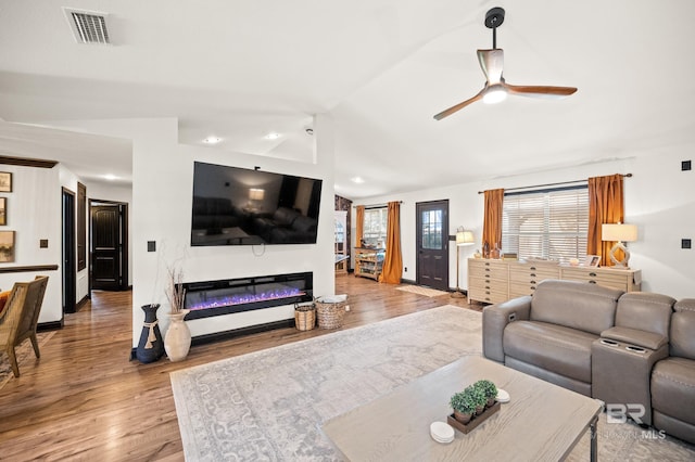 living room featuring hardwood / wood-style flooring, ceiling fan, and vaulted ceiling