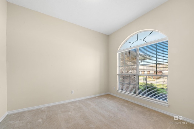 unfurnished room with baseboards, carpet, and vaulted ceiling