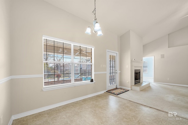 unfurnished living room featuring a chandelier, high vaulted ceiling, and baseboards