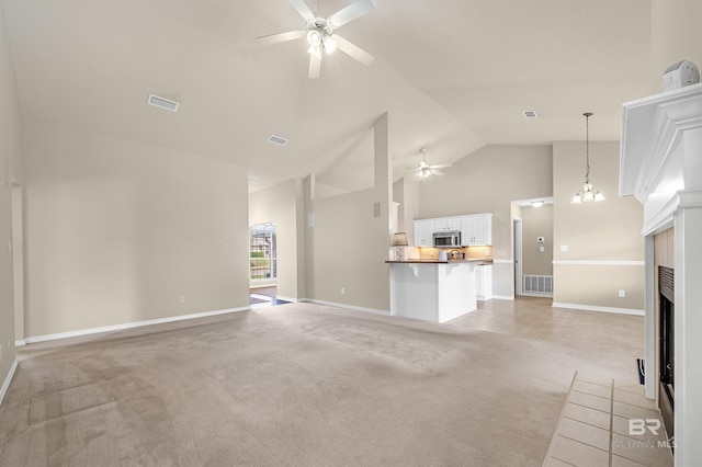 unfurnished living room with visible vents, light colored carpet, high vaulted ceiling, and a ceiling fan