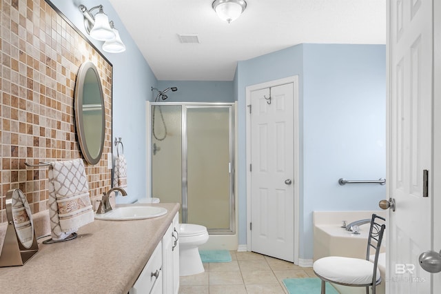 bathroom featuring tile patterned floors, toilet, a stall shower, a bath, and vanity