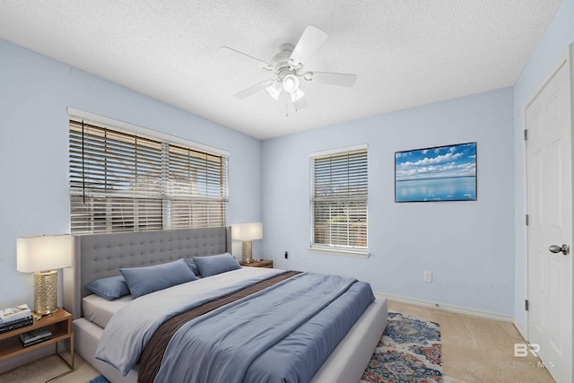 bedroom with ceiling fan, carpet, baseboards, and a textured ceiling