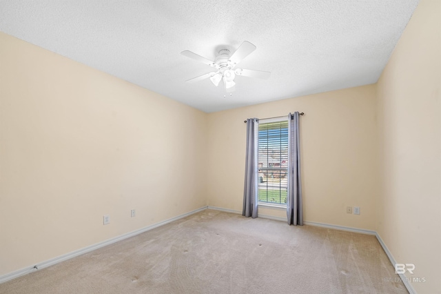 unfurnished room with baseboards, light colored carpet, a ceiling fan, and a textured ceiling