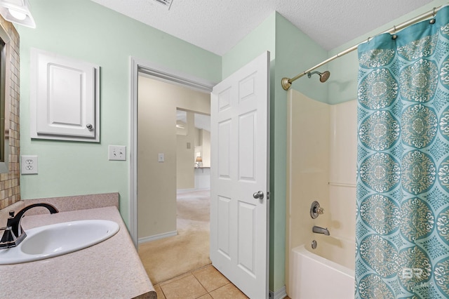 bathroom with vanity, tile patterned floors, shower / tub combo with curtain, and a textured ceiling