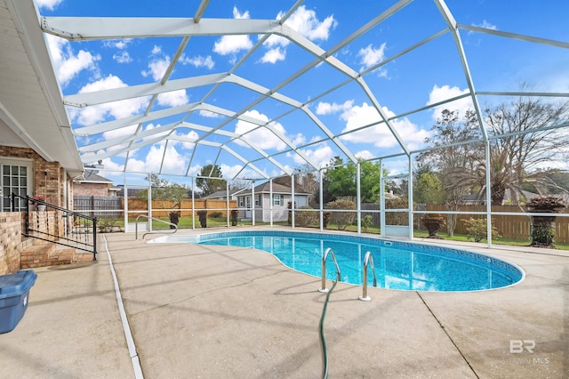 view of swimming pool with glass enclosure, a fenced in pool, a patio area, and fence