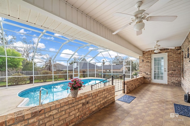 view of swimming pool with a ceiling fan, fence, a fenced in pool, a lanai, and a patio area