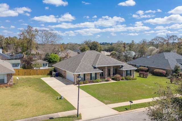 view of front of property featuring a shingled roof, fence, a front yard, a garage, and driveway