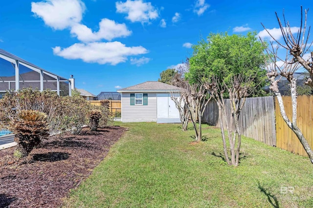 view of yard with an outbuilding, a shed, glass enclosure, and a fenced backyard