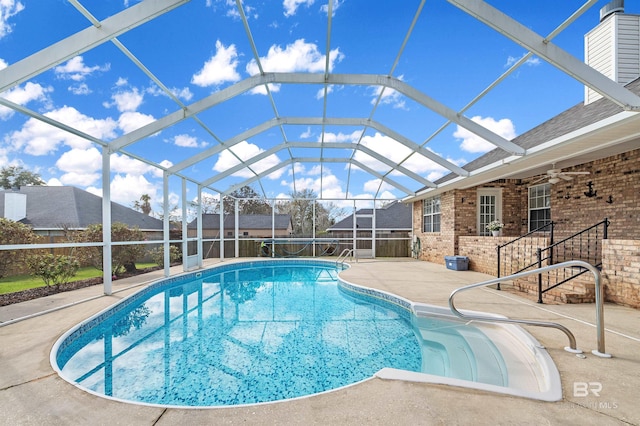 view of swimming pool with a ceiling fan, a lanai, a patio area, and a fenced in pool