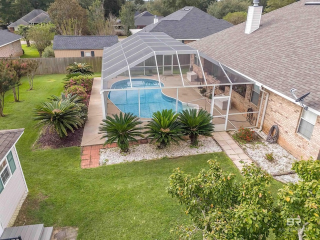 view of swimming pool featuring a fenced in pool, a lawn, glass enclosure, a fenced backyard, and a patio